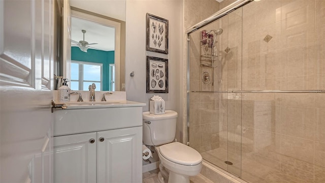 bathroom with vanity, ceiling fan, toilet, and an enclosed shower