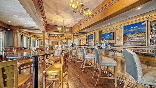 dining area featuring wood-type flooring, ornate columns, coffered ceiling, bar, and beam ceiling