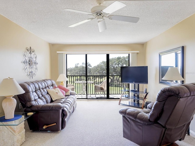 living room with a textured ceiling, ceiling fan, and carpet