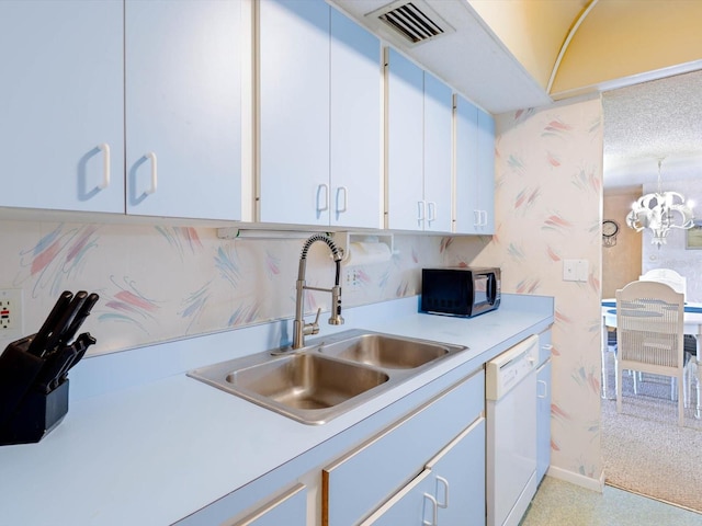 kitchen featuring sink, a notable chandelier, dishwasher, and white cabinetry