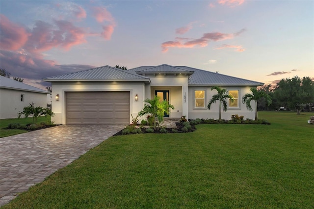 view of front of home with a lawn and a garage