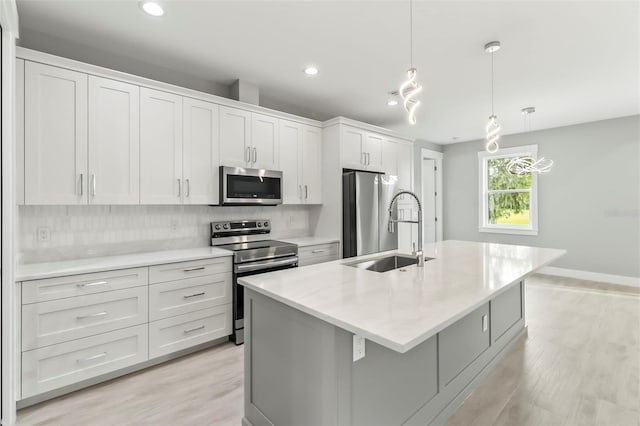 kitchen with backsplash, light hardwood / wood-style floors, appliances with stainless steel finishes, and white cabinetry