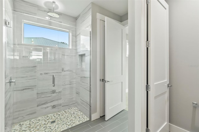 bathroom featuring a shower with door and tile flooring