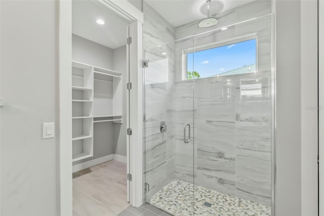 bathroom with a shower with door and tile flooring