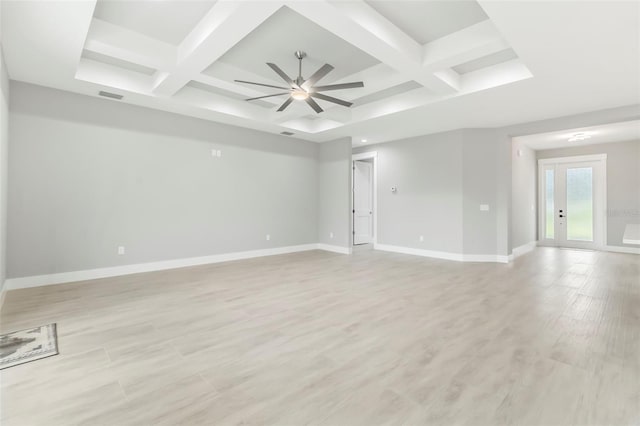 empty room featuring coffered ceiling, ceiling fan, french doors, beamed ceiling, and light wood-type flooring