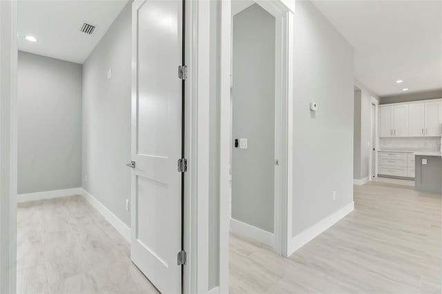 hallway with light hardwood / wood-style floors