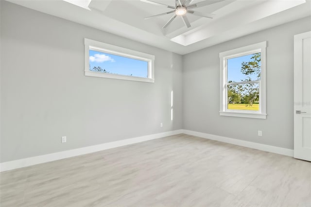 empty room featuring plenty of natural light, ceiling fan, and light hardwood / wood-style flooring