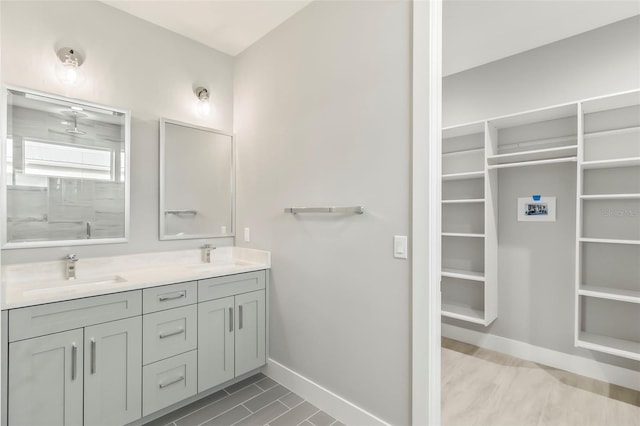 bathroom featuring oversized vanity, tile floors, and dual sinks