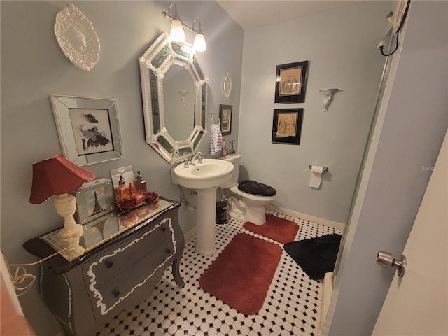 bathroom featuring toilet, tile floors, and sink