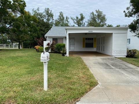 view of front of property with a carport and a front yard