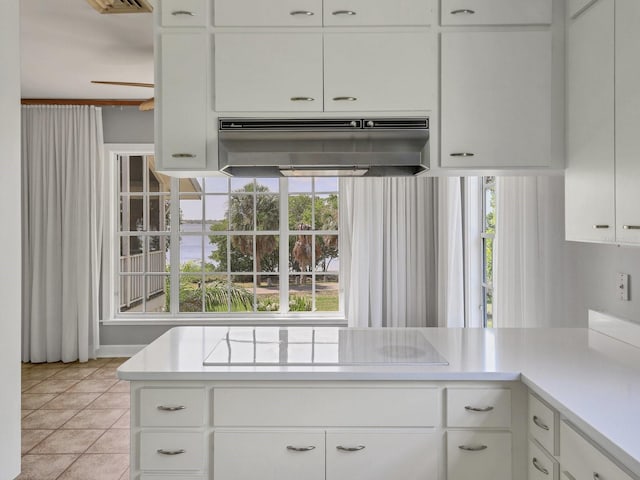 kitchen with extractor fan, white cabinetry, black electric stovetop, and light tile floors