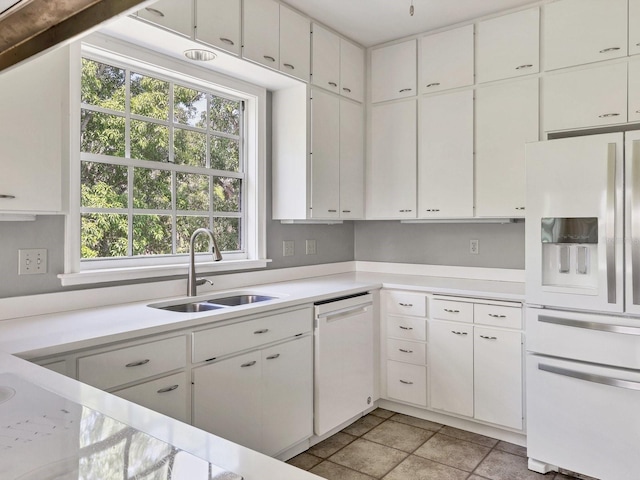 kitchen with white cabinets, plenty of natural light, white appliances, and sink