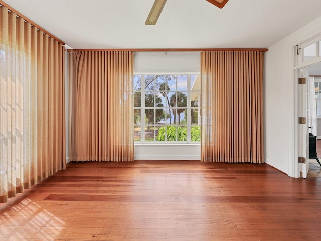 empty room with ceiling fan and hardwood / wood-style flooring