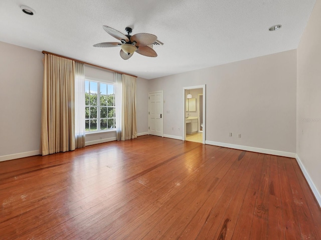 spare room featuring a textured ceiling, dark hardwood / wood-style floors, and ceiling fan