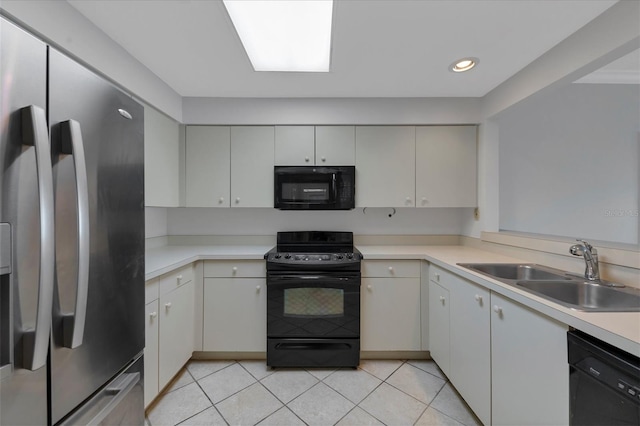 kitchen with white cabinets, sink, light tile floors, and black appliances