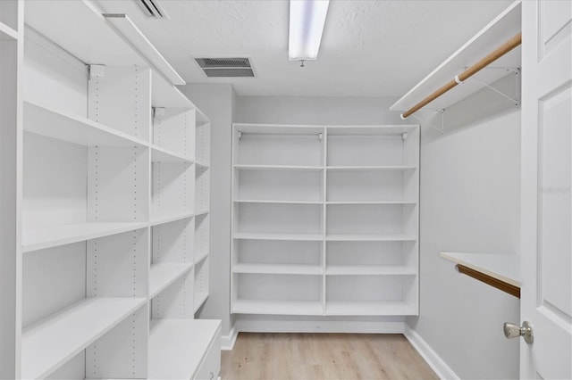 spacious closet featuring light hardwood / wood-style floors