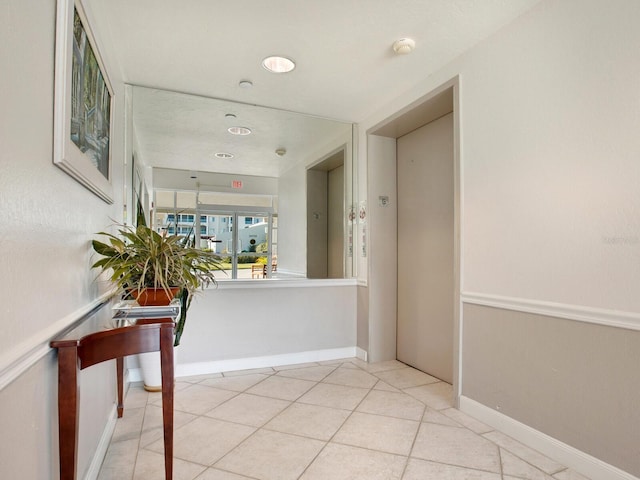 hall featuring light tile floors and elevator