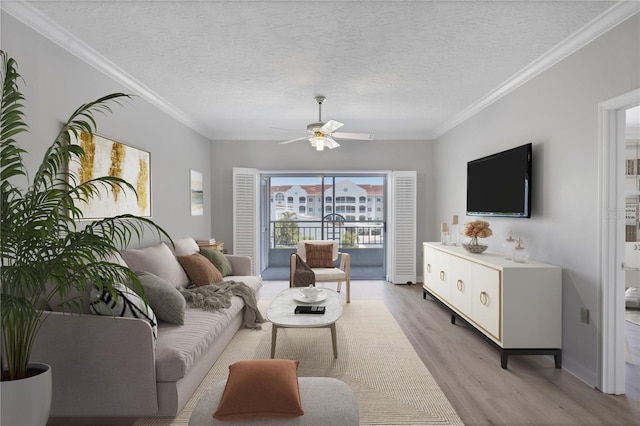 living room with light hardwood / wood-style flooring, crown molding, ceiling fan, and a textured ceiling