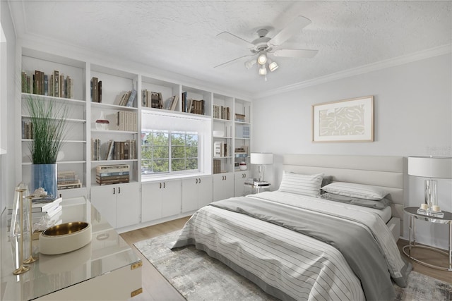 bedroom with crown molding, ceiling fan, a textured ceiling, and light wood-type flooring