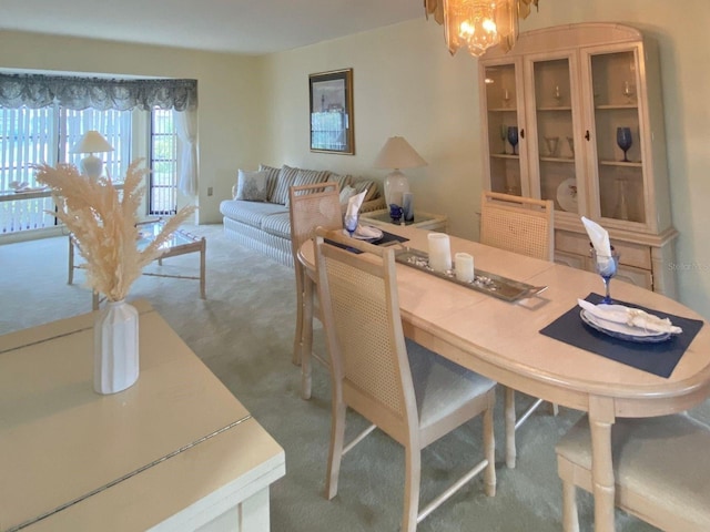 dining space featuring carpet flooring and an inviting chandelier