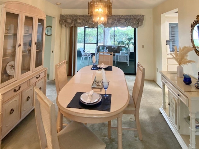 dining area with a chandelier and light colored carpet