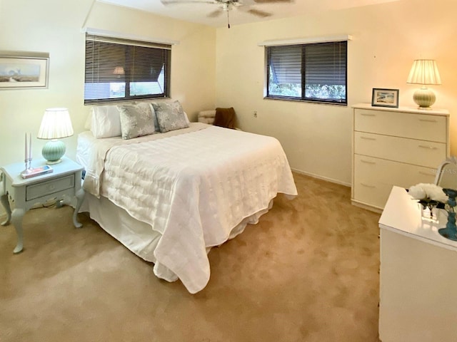 carpeted bedroom featuring ceiling fan and multiple windows