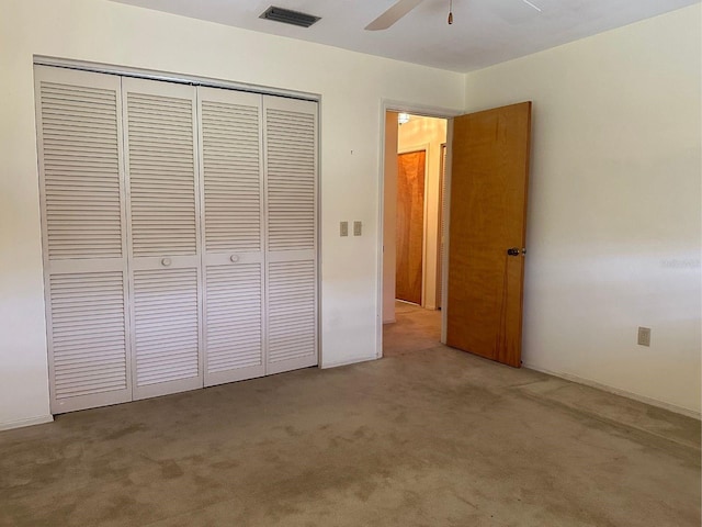 unfurnished bedroom featuring carpet flooring, ceiling fan, and a closet