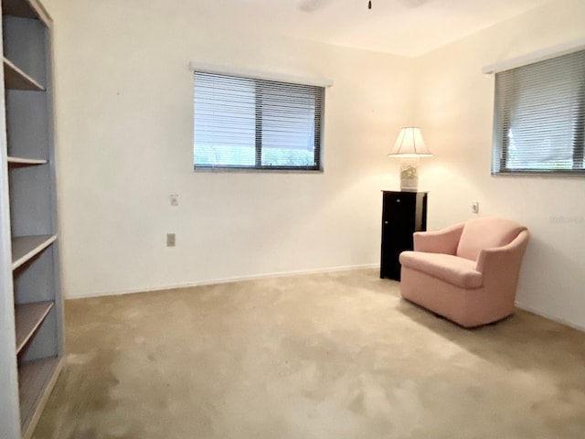 living area with light carpet and ceiling fan