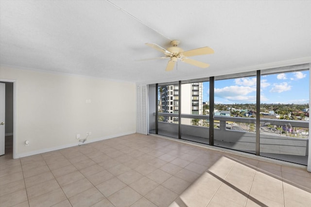 tiled spare room with expansive windows, ceiling fan, and crown molding