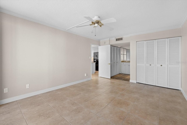 unfurnished bedroom with ceiling fan, crown molding, light tile patterned flooring, and a textured ceiling