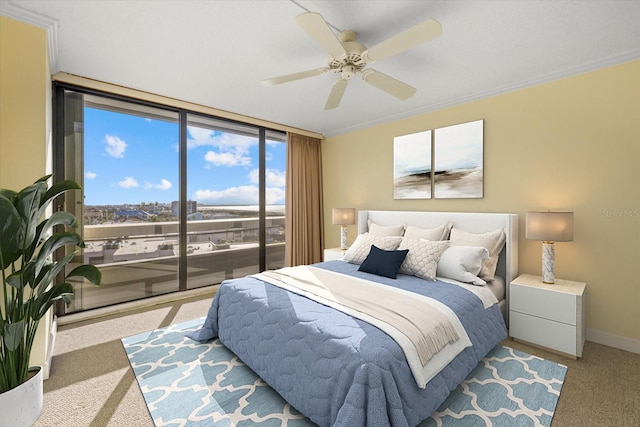 carpeted bedroom featuring ceiling fan, expansive windows, and crown molding