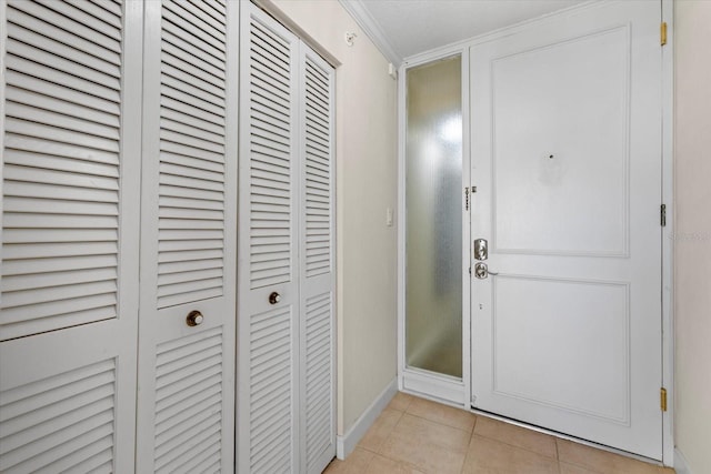 entryway featuring light tile patterned flooring and crown molding