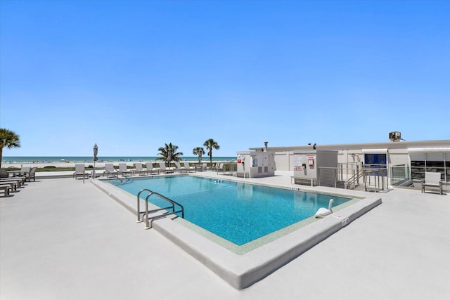 view of swimming pool featuring a patio area and a water view