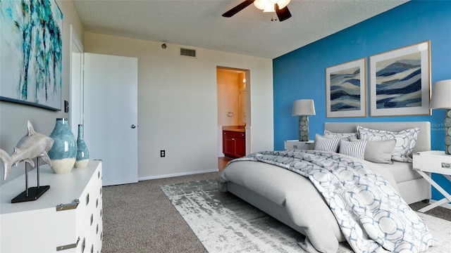 bedroom featuring ceiling fan, ensuite bathroom, carpet flooring, and a textured ceiling