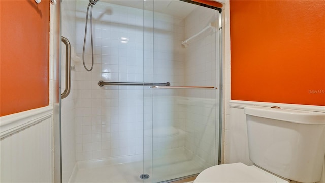 bathroom with a shower with shower door and toilet