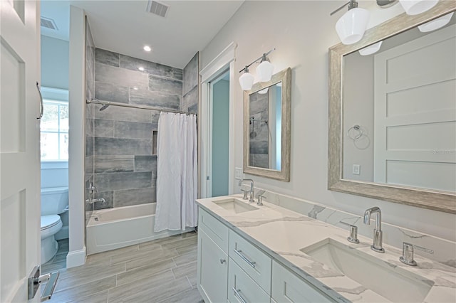 full bathroom with shower / bath combo with shower curtain, toilet, double vanity, and tile floors