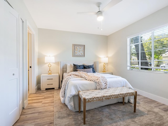 bedroom with ceiling fan, a closet, and light hardwood / wood-style flooring