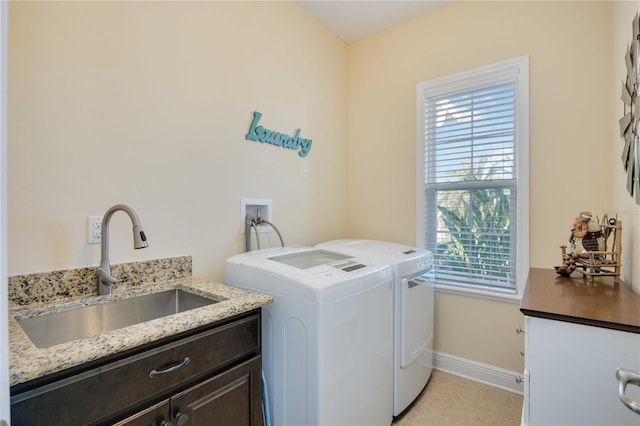 washroom featuring cabinets, light tile patterned floors, washing machine and dryer, and sink