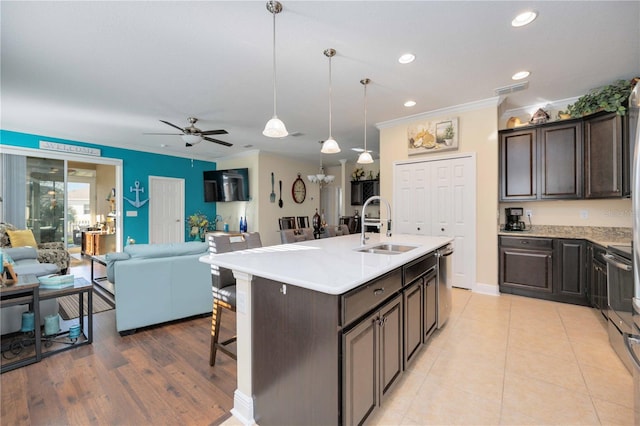 kitchen featuring sink, ceiling fan, pendant lighting, a kitchen island with sink, and stainless steel dishwasher