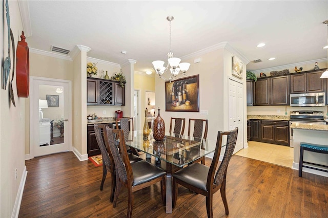 dining room with hardwood / wood-style flooring, an inviting chandelier, and ornamental molding