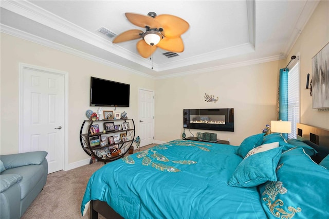 bedroom with crown molding, light colored carpet, ceiling fan, and a tray ceiling