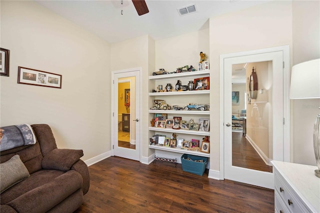 living area featuring ceiling fan and dark hardwood / wood-style flooring