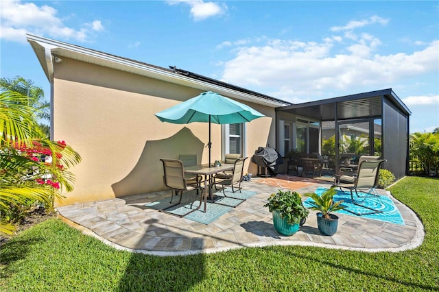 rear view of house featuring a sunroom, a lawn, and a patio