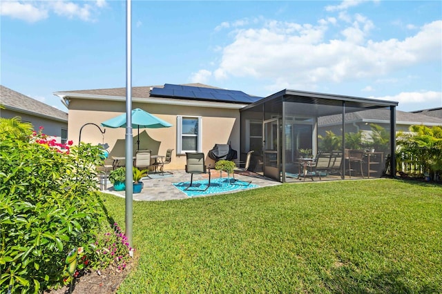 back of property featuring a yard, a patio area, solar panels, and a sunroom