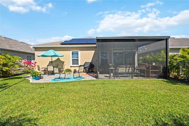 rear view of property featuring a lawn, a patio, and solar panels