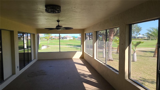 unfurnished sunroom featuring ceiling fan