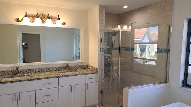 bathroom featuring a shower with door, a healthy amount of sunlight, and vanity