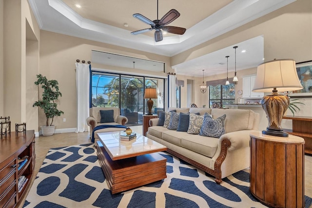 living room with ornamental molding, a raised ceiling, and ceiling fan