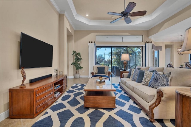 living room featuring ornamental molding, light tile patterned flooring, a raised ceiling, and ceiling fan