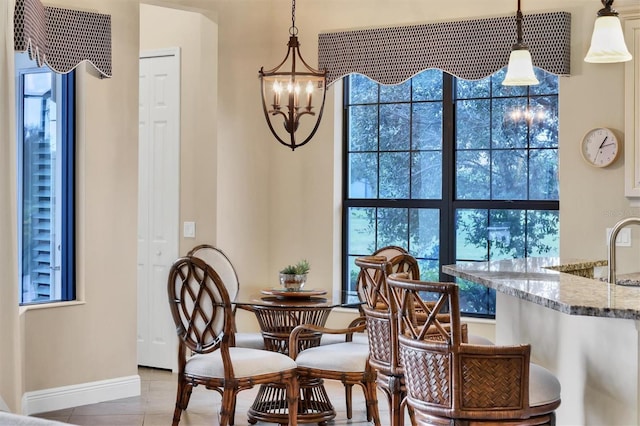 dining area with light tile patterned floors and an inviting chandelier